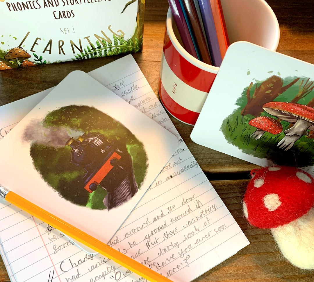 Train storytelling card and mushroom card with pot of pencils and writing book.