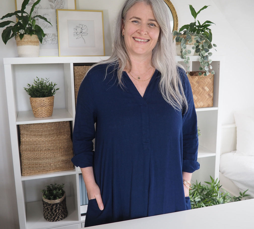 Founder of The Phive standing behind desk smiling.