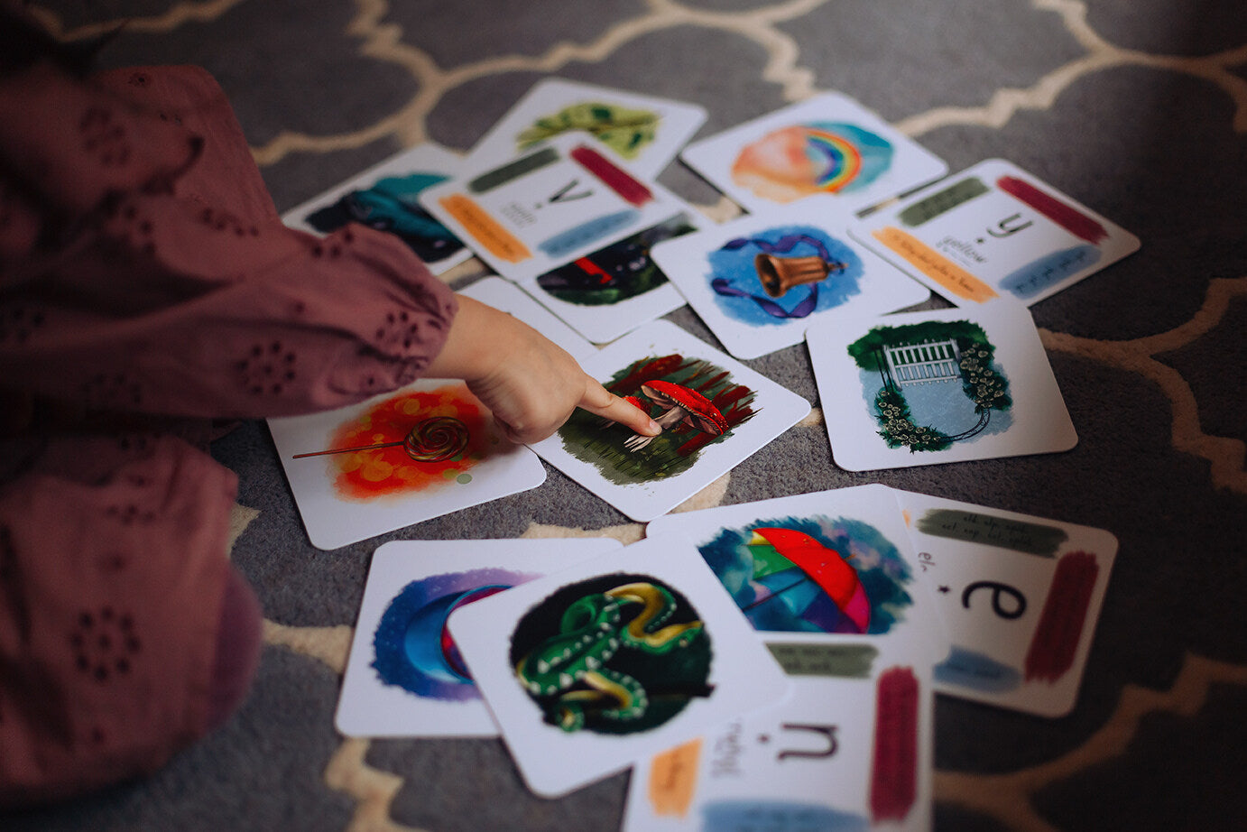 Selection of phonics cards being sorted through by young child.