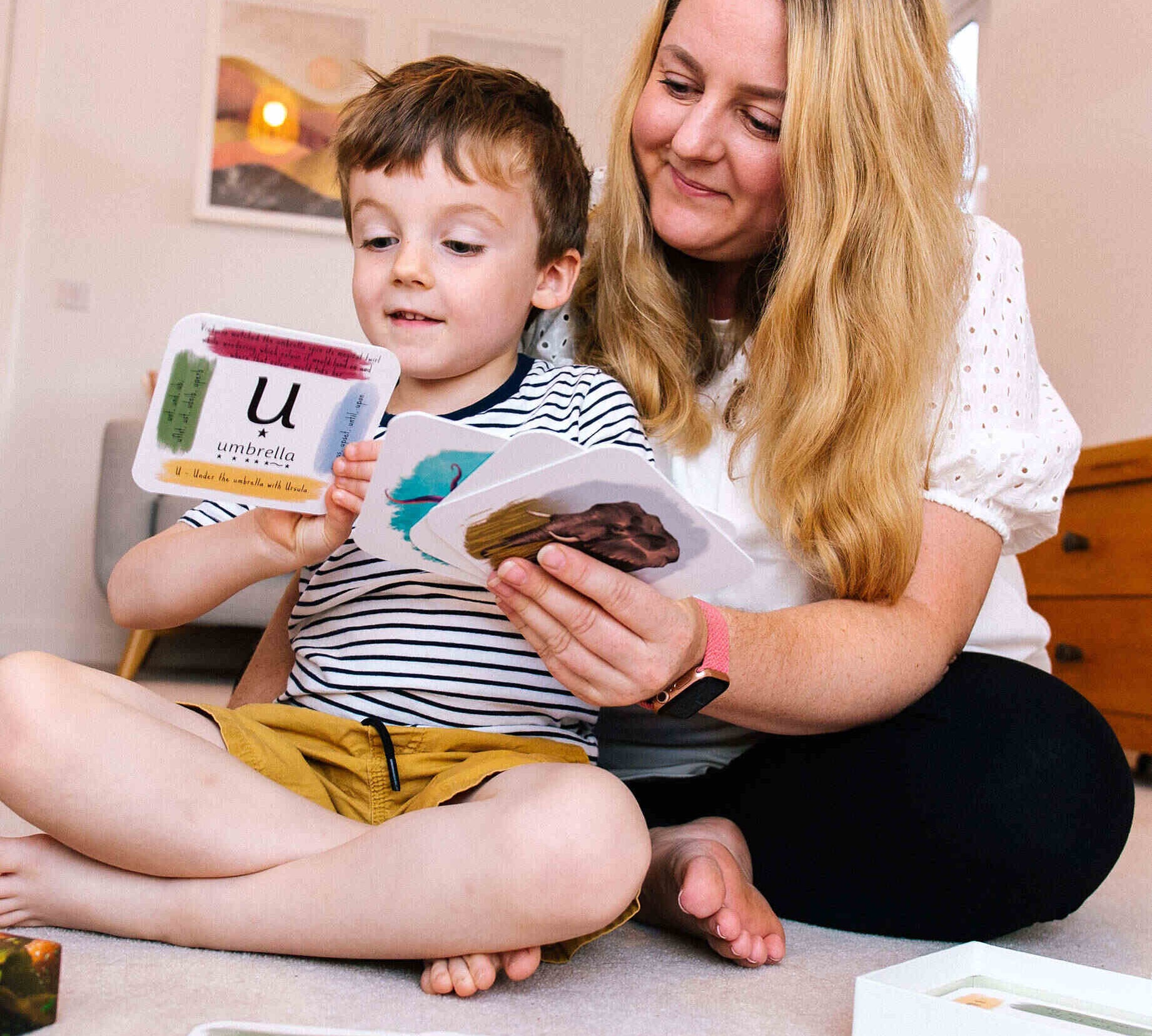 Mother and child using phonics cards together.