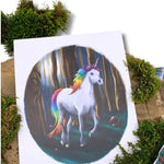 Rainbow unicorn print on a mossy log.