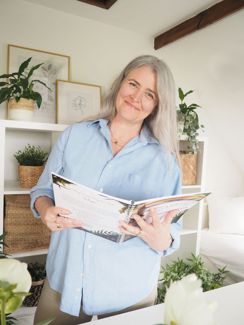 Woman smiling while holing story writing book.