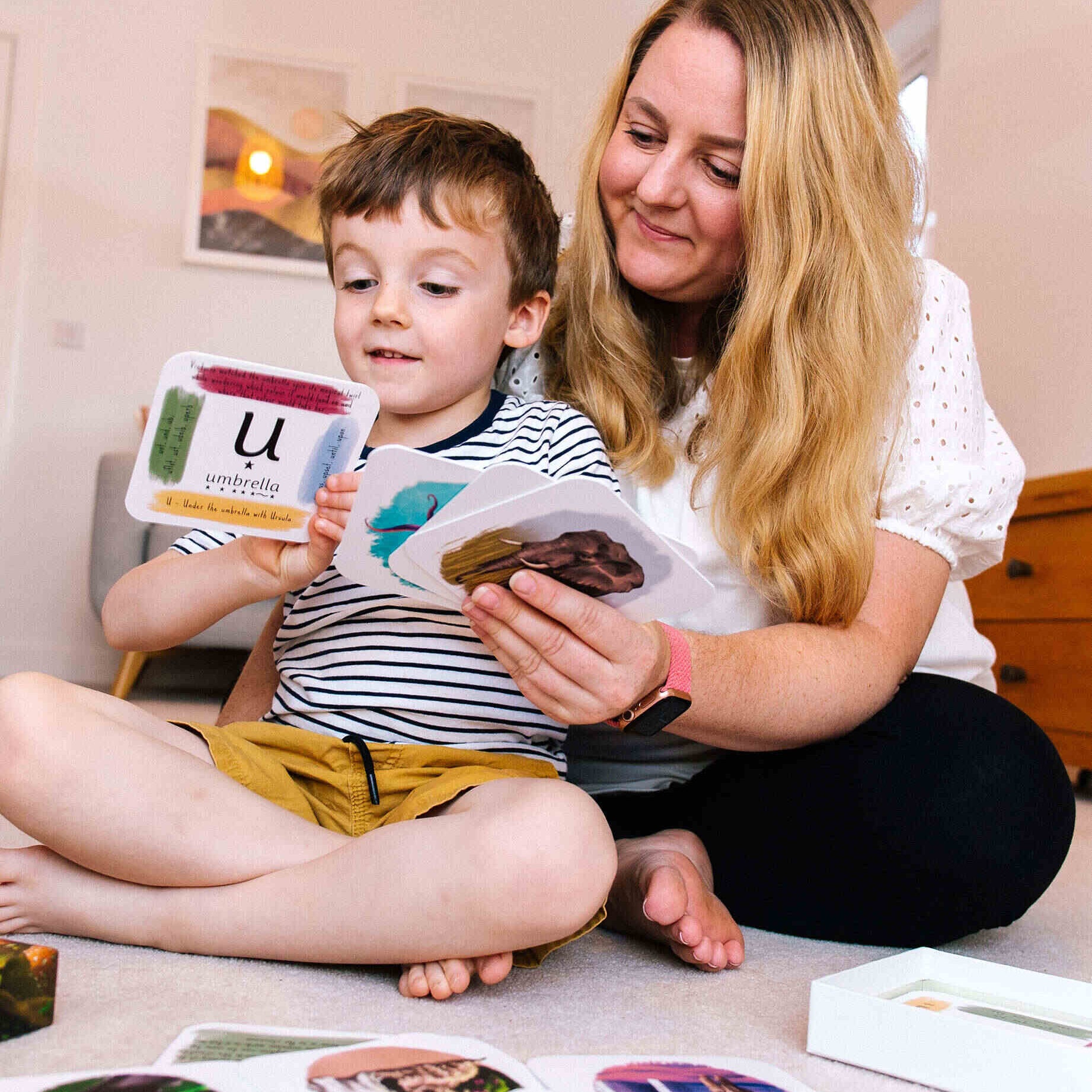 Mother and child using phonics cards together.