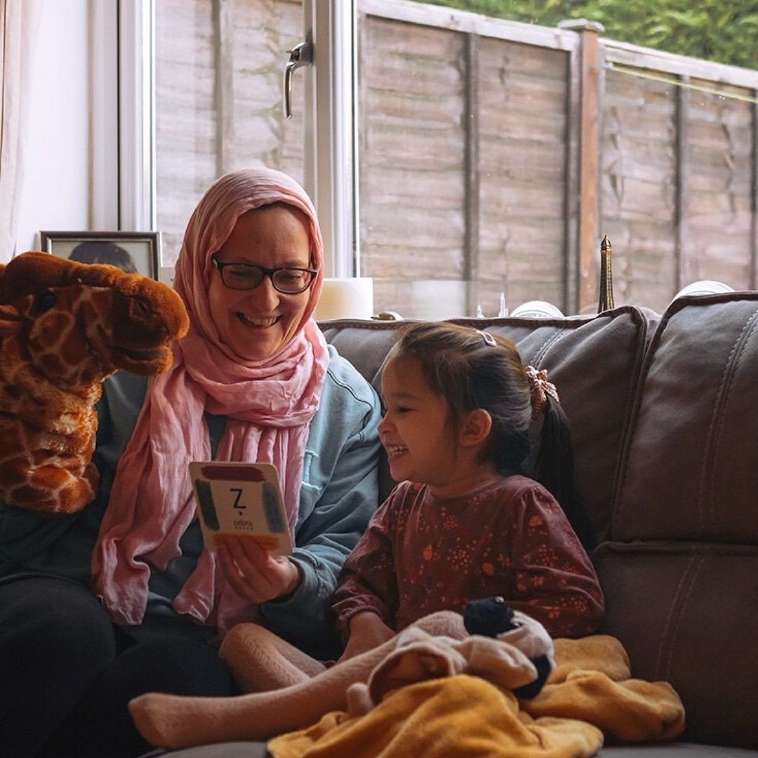 Mother and daughter storytelling together with a puppet.