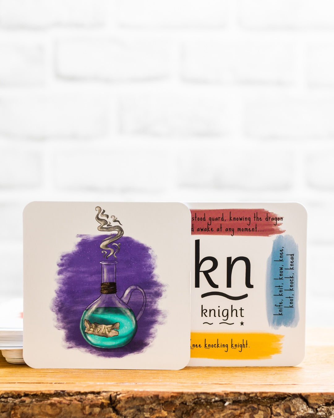 Potion and knight phonics cards on a wooden shelf.