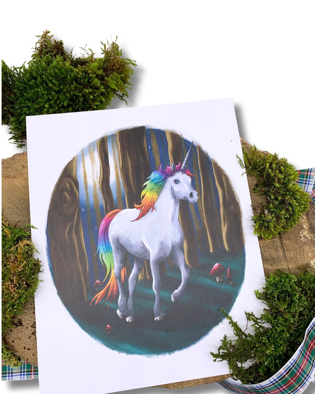 Rainbow unicorn print on a mossy log.