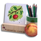 A phonics card showing an apple set in a wooden card stand.