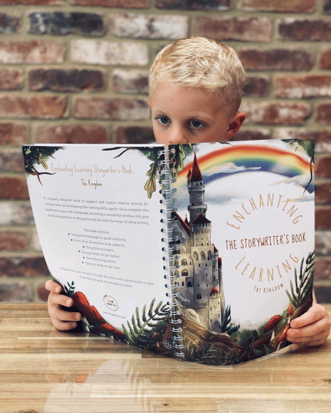 Young boy reading a story in his story writing book.