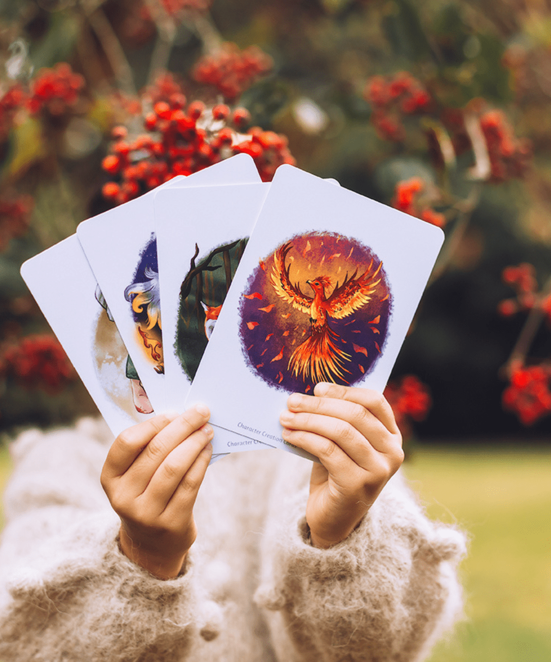 Girl in woods holding story writing cards showing phoenix .