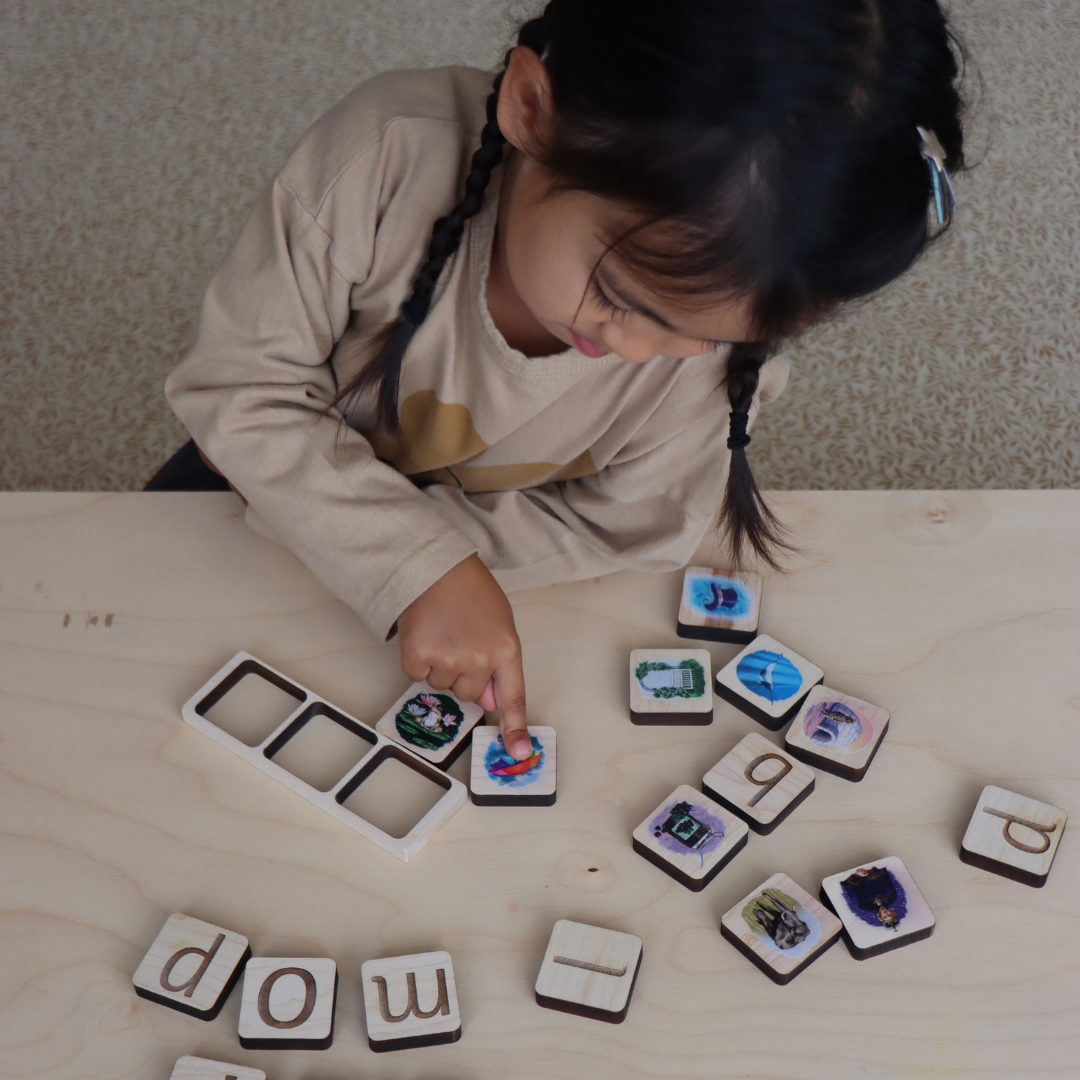 Child playing with letter tiles on a wooden surface