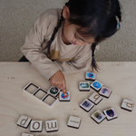 Child playing with letter tiles on a wooden surface