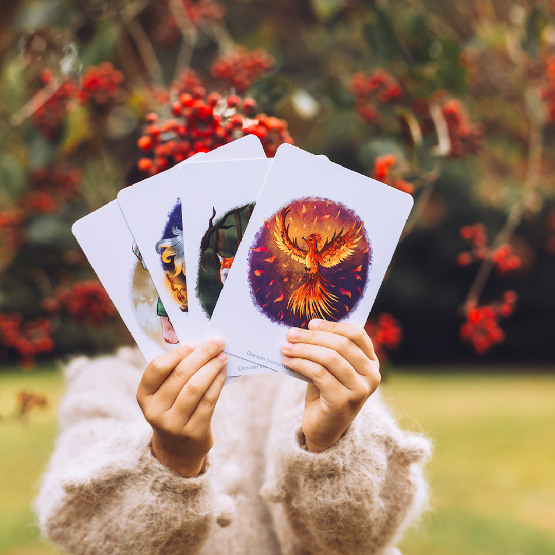 child stnding in a garden holding a phoenix card.
