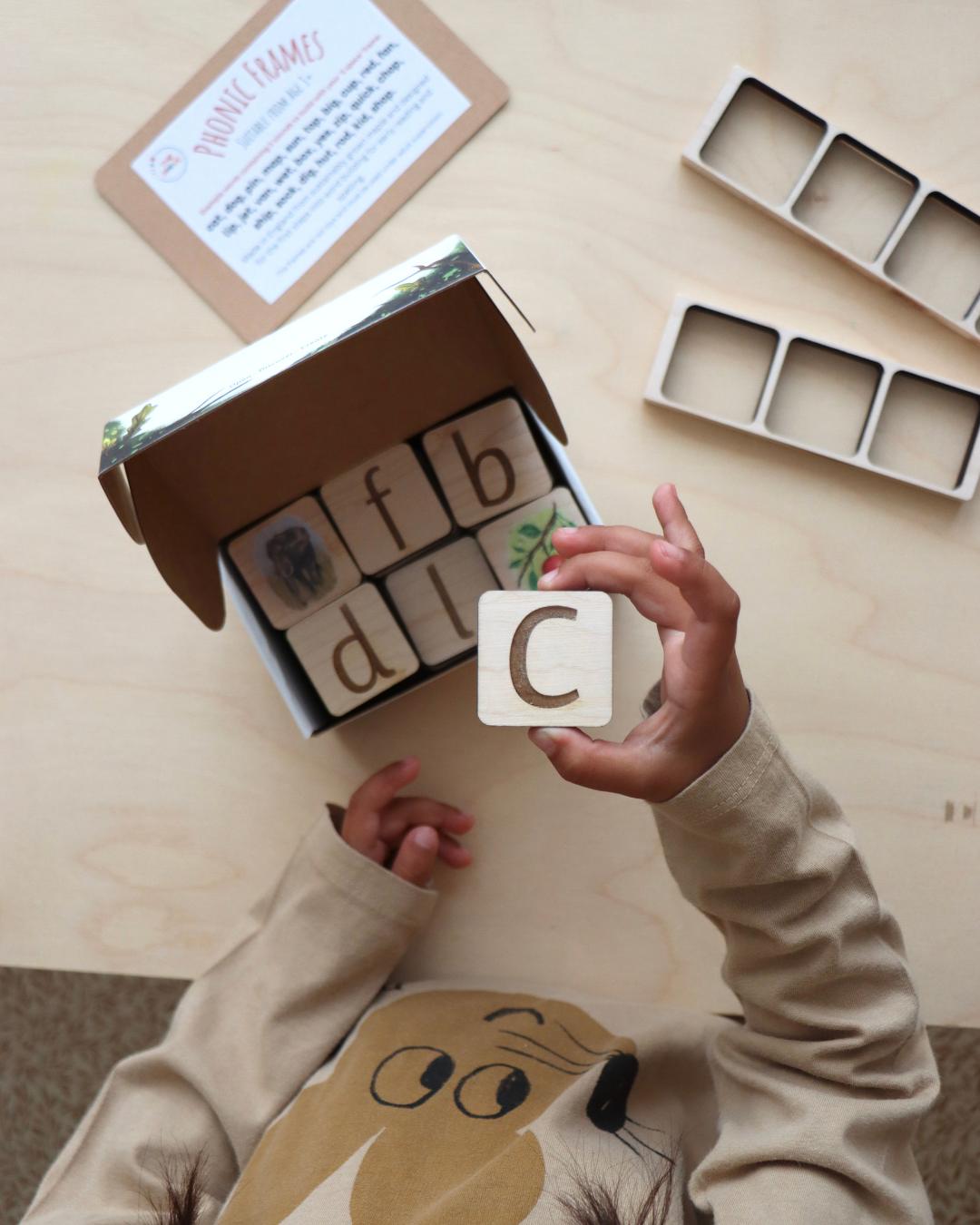 Child exploring a box of maple wood tiles.