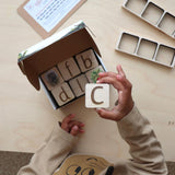 Child exploring a box of maple wood tiles.