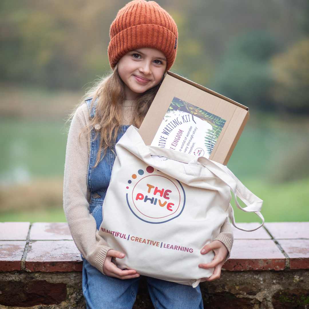 A young girl say on a wall holding a bag full of creative writing supplies by The Phive.