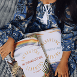 A girl in a blue dress holding two story writing books.