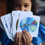 Smiling girl holding fanned out Set 3 phonics cards.