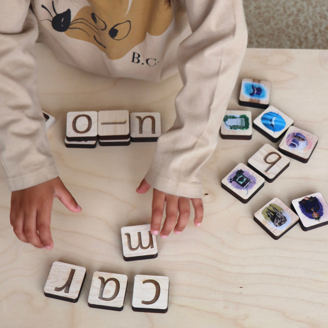 girl playing with wooden tiles to build words.