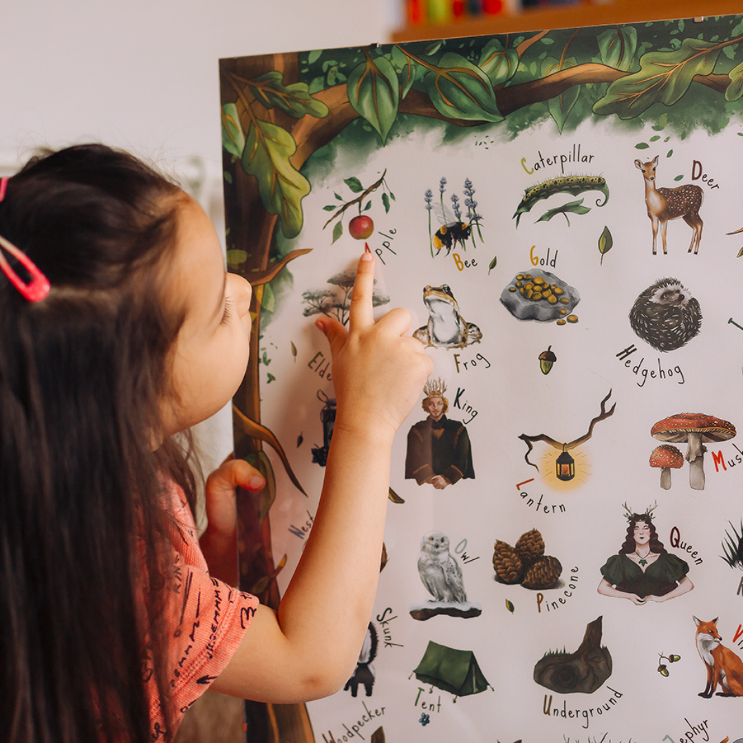 young girl pointing to an apple on a woodland poster.