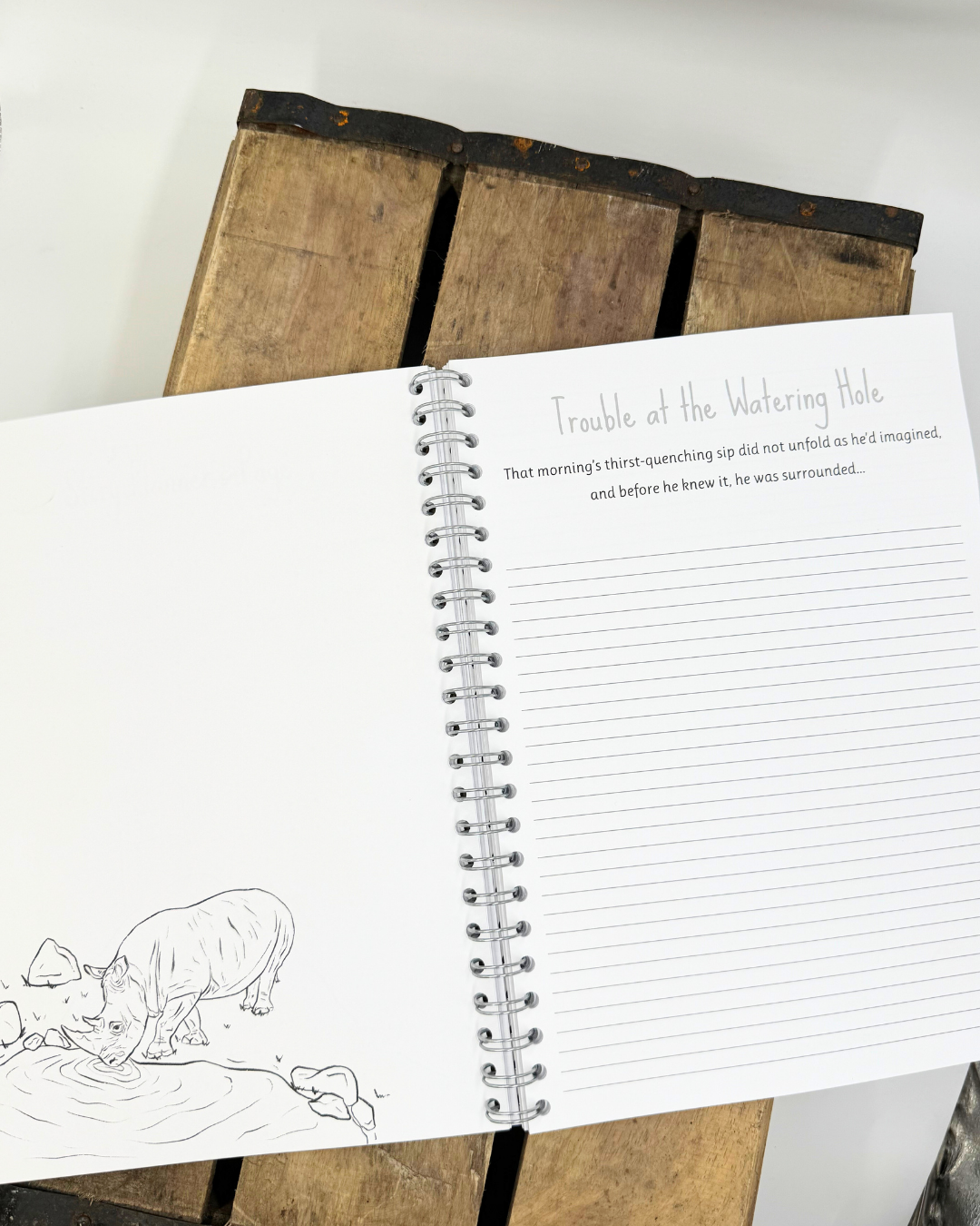 An inside pageof a jungle themed writing book shwoing a rhino.