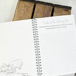 An inside pageof a jungle themed writing book shwoing a rhino.