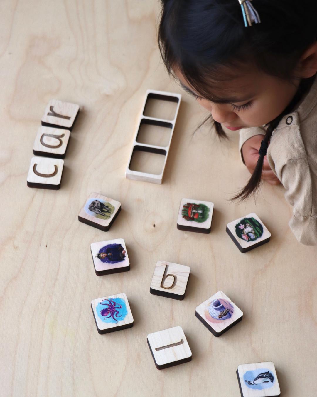 Child looking at maple wood phonics tiles.