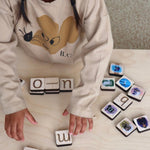 Girl playing with maple wood tiles.