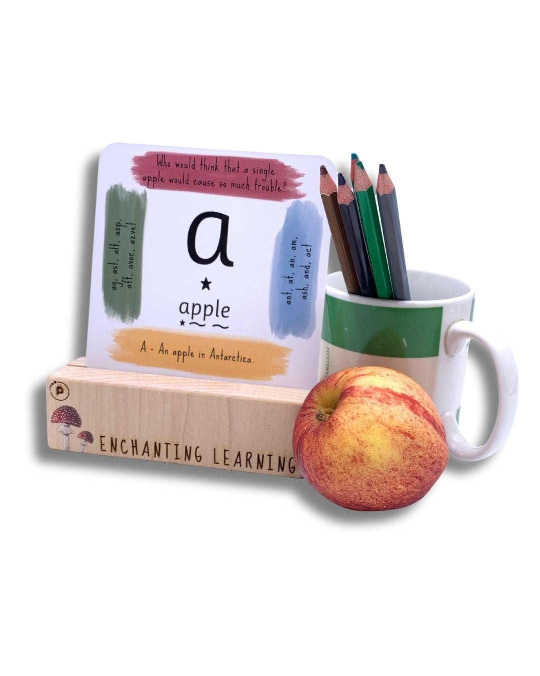 Phonic card showing  grapheme card standing in a wooden card stand for phonics cards with an apple and a pot of pencils.