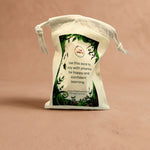 White drawstring phonics sack with green leaf design and text on a beige background