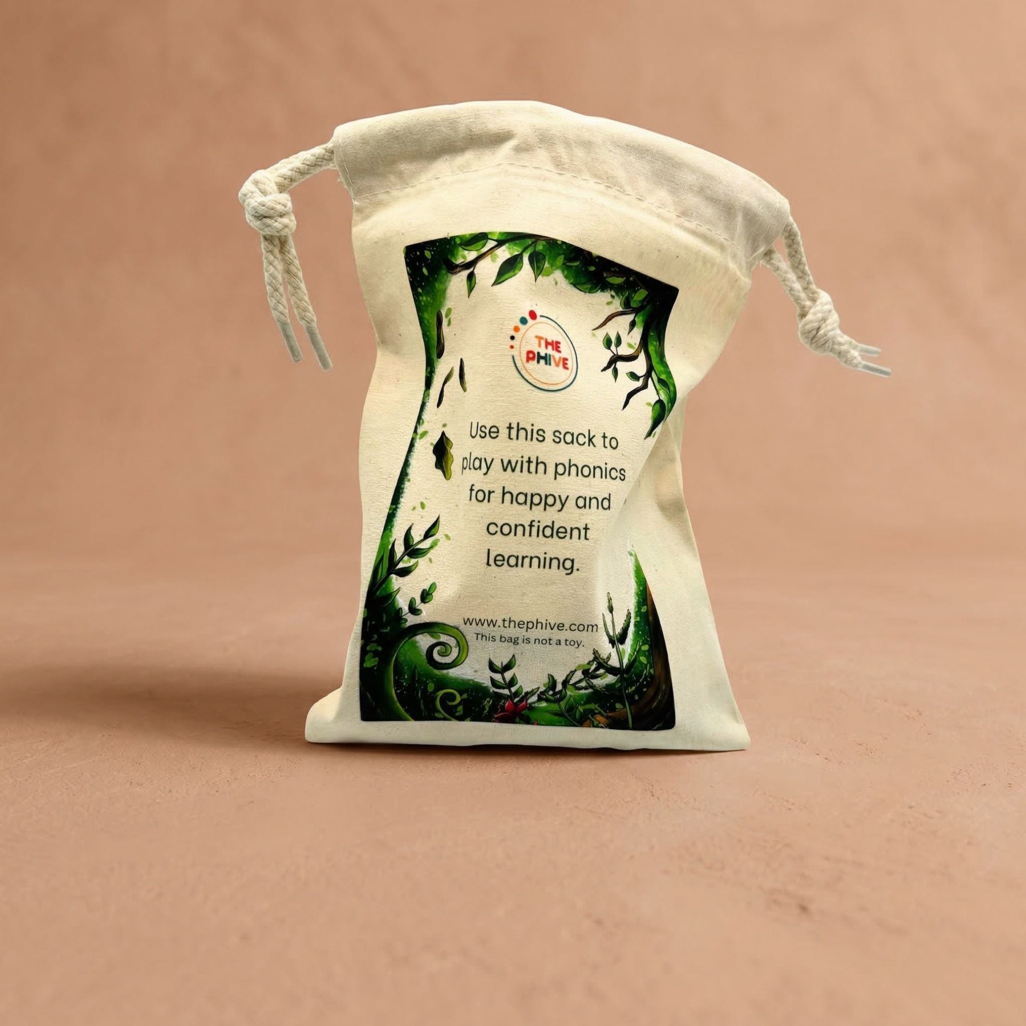 White drawstring phonics sack with green leaf design and text on a beige background