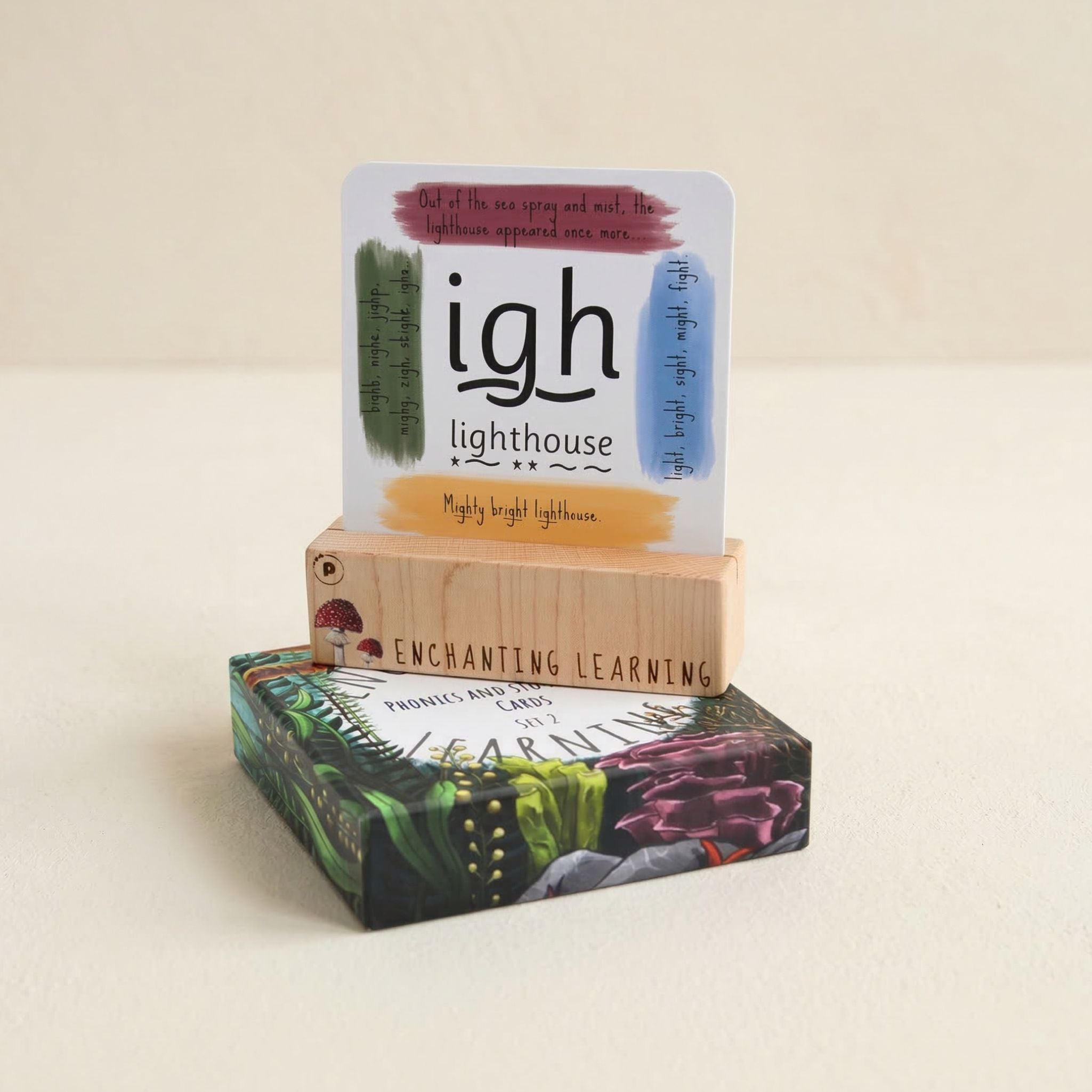 a phonics cards box and wooden stand  with 'igh lighthouse' and 'Enchanting Learning' branding on a beige background