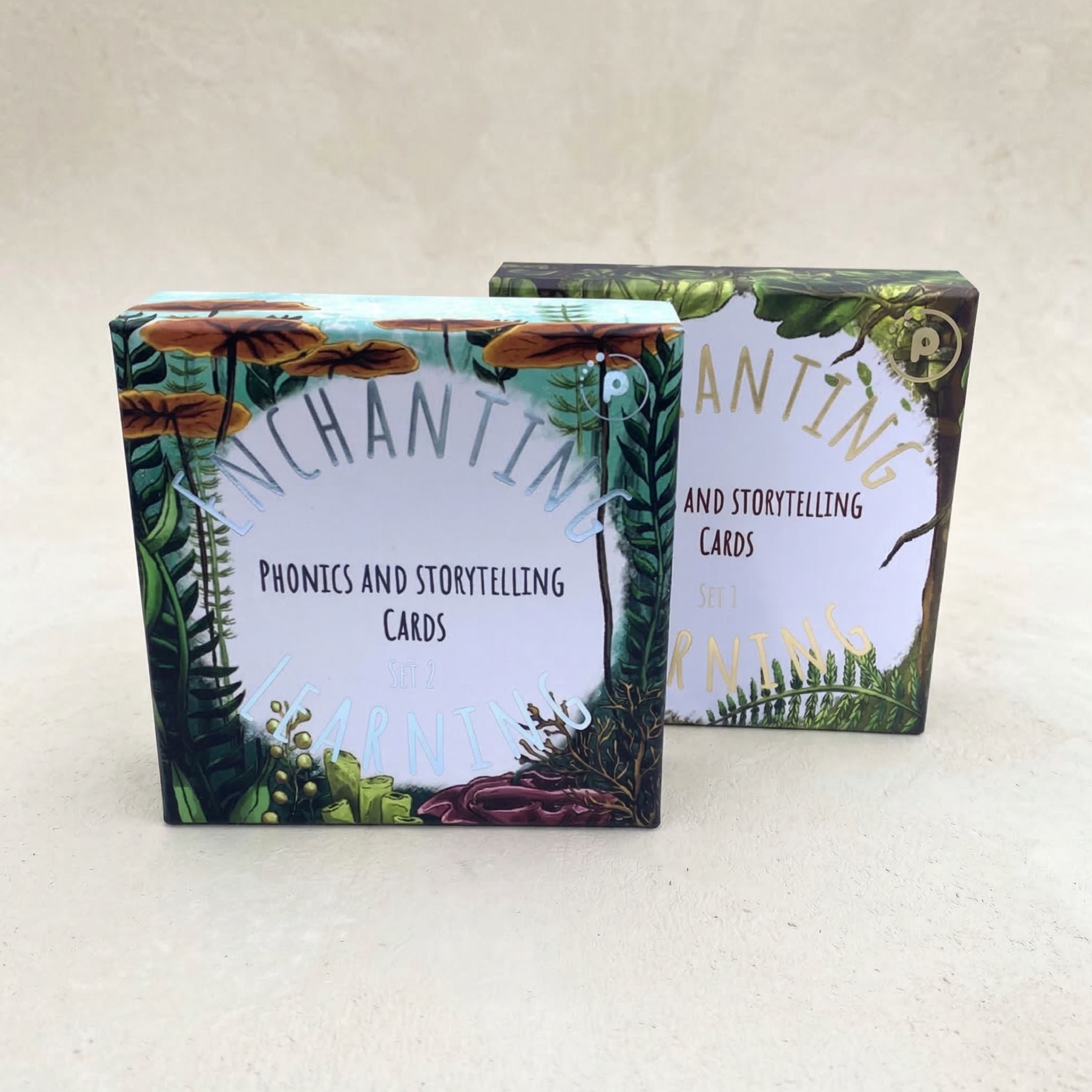 Two boxes of 'Enchanting Learning ' phonics and storytelling cards on a white background