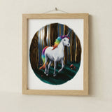 Framed artwork of a unicorn with a rainbow mane and tail in a forest setting.