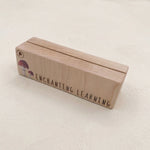 Wooden learning card holder with 'Enchanting Learning' text on a light background