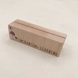 Wooden learning card holder with 'Enchanting Learning' text on a light background