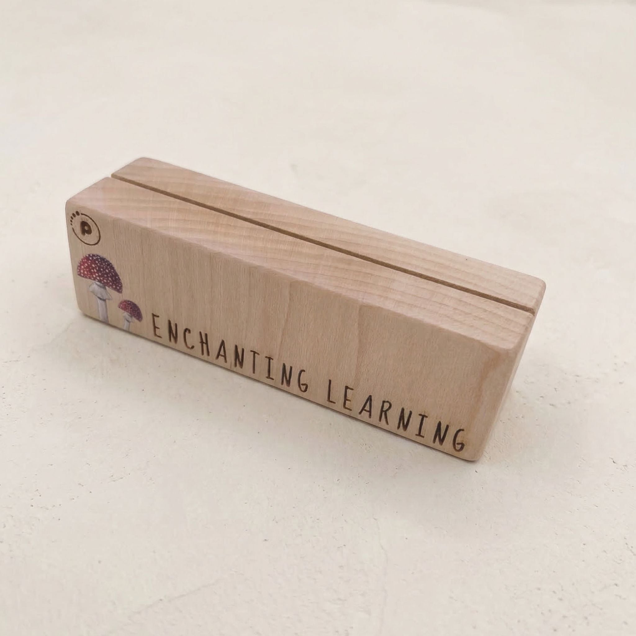 Wooden learning card holder with 'Enchanting Learning' text on a light background