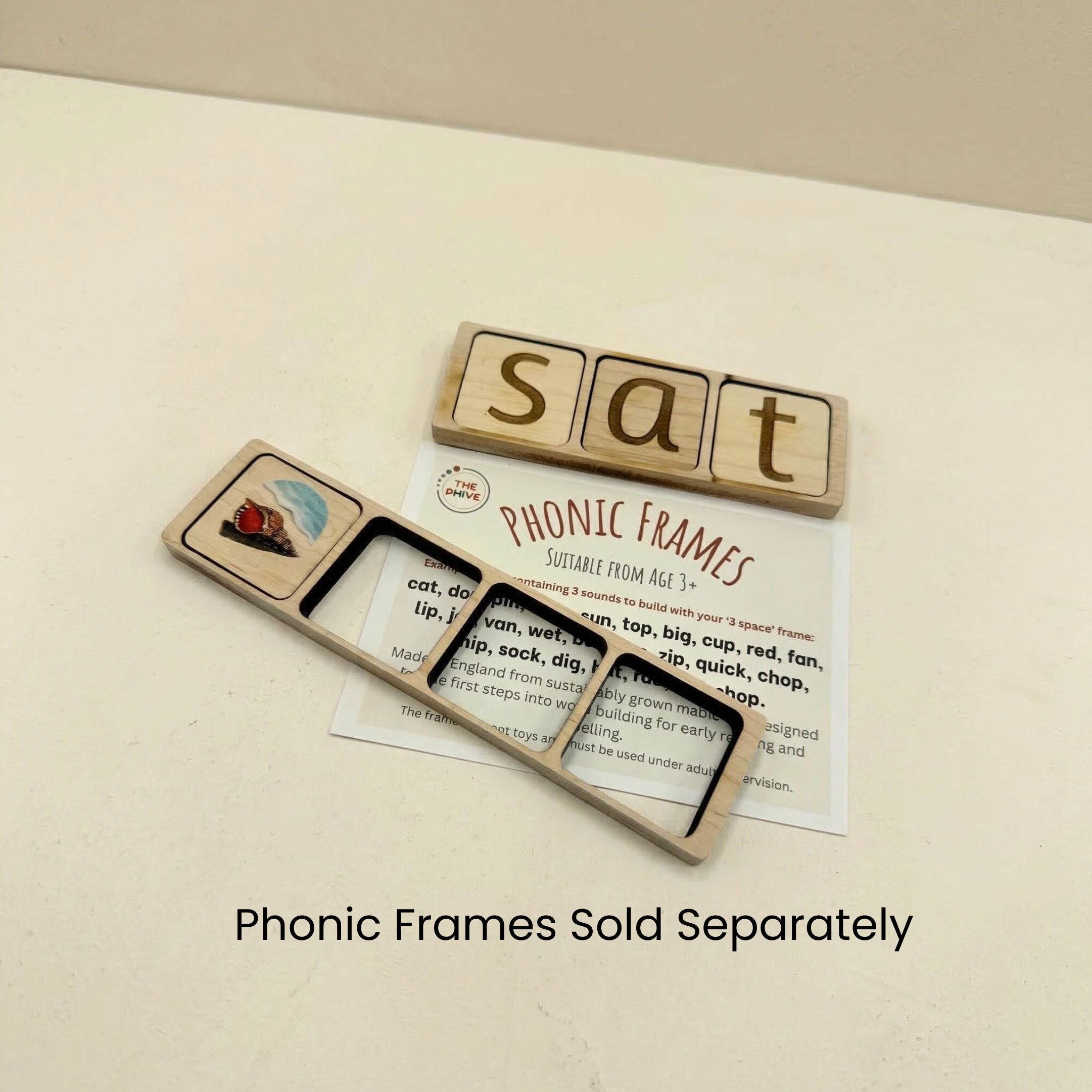 Wooden frames laying on an instruction card spelling the word sat on a light background.
