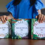 a girl holding three sets of phonics cards.