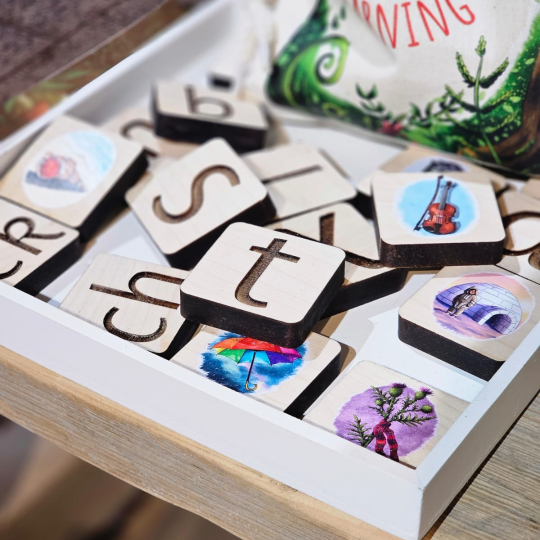 Wooden letter tiles with images on a white tray