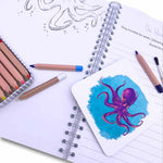 Writing book open at illustration page showing octopus phonics card.